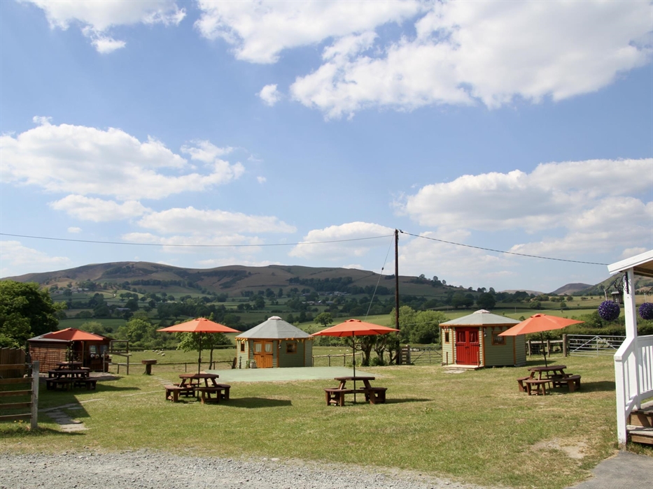 The yurt field at Barnutopia with a view of the Gyrn Moelfre, Powys in the background.