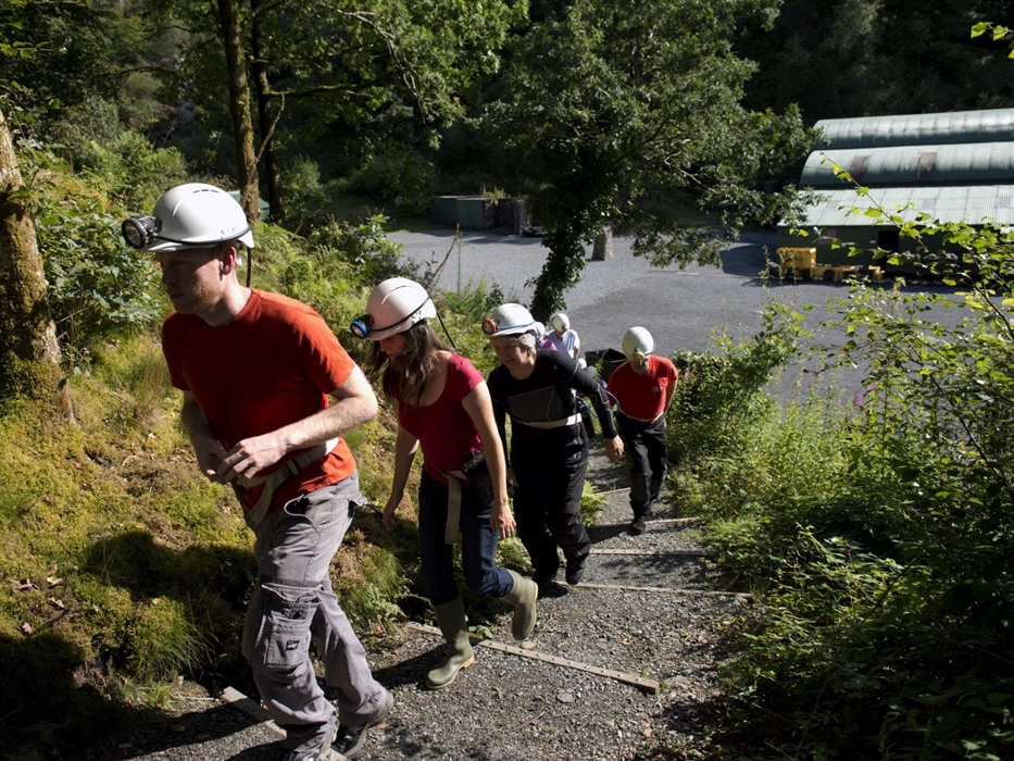 People setting off up steps to a dark Victorian drift mine