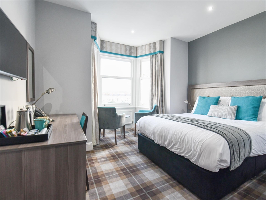 Bright, serene, and thoughtfully designed, this room offers the perfect retreat with a spacious bed, cozy seating by the window, and everything you ne