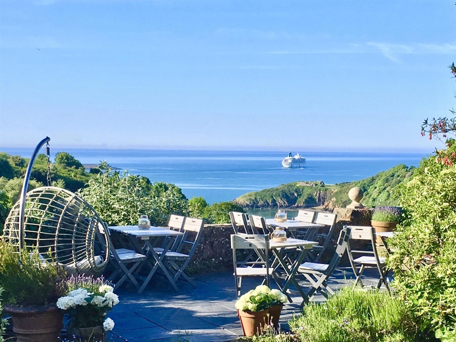 Views from the bottom of the garden overlooking Cardigan Bay and  Fishguard Lower Town on a summer’s evening. The terrace is dotted with potted hydran