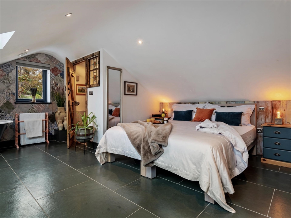 first floor bedroom offering superking or twin beds, bedside cupboards, en-suite with basin, w.c. and chest of drawers, roll top bath, smart TV, dress