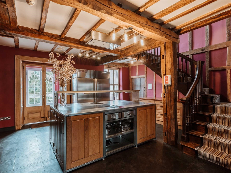 The semi-commercial kitchen features 3 ovens, 2 two-ring induction hobs, 1 four-ring induction hob and microwave, 2 door commercial fridge and single