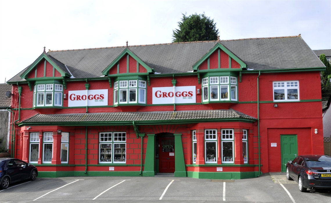 Photo shows a front view of the red and green building that has been The Groggshop since 1971.