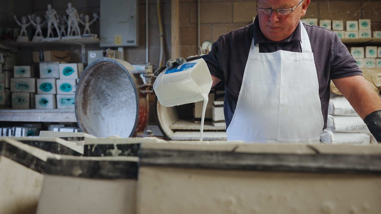 The photo shows a man pouring resin into a mould.