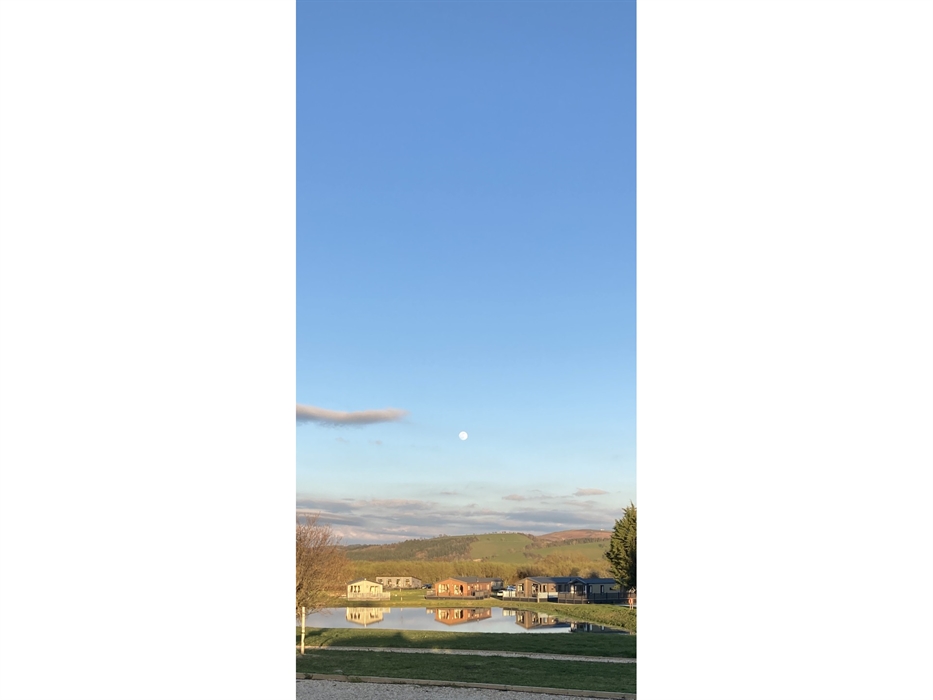 Lodges reflected in the lake, with the moon above