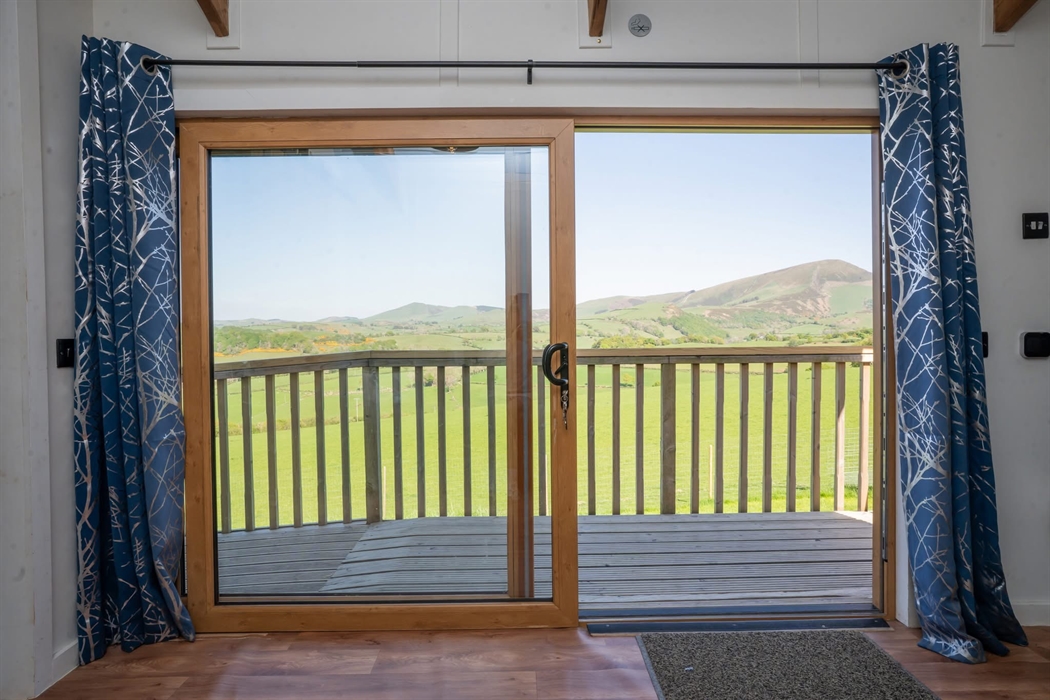 View when sitting on your rise and recliner looking out across to the Cambrian mountains, and below into the Dyfi valleys. A vibrant colour of greens,