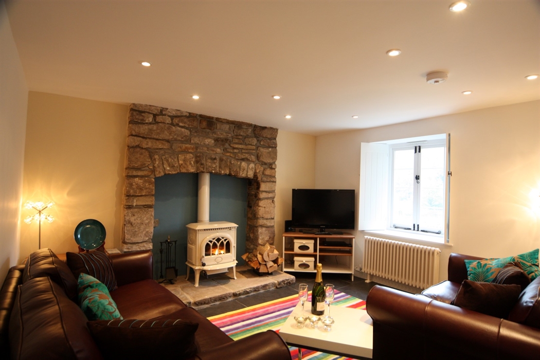Comfortable sitting room with squishy sofas, woodburner and TV