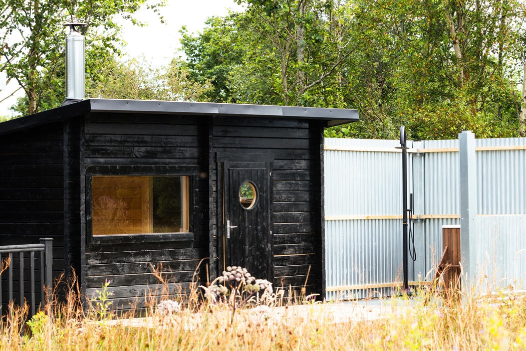 Wood-fired sauna in the meadow, with cold plunge and an outdoor shower