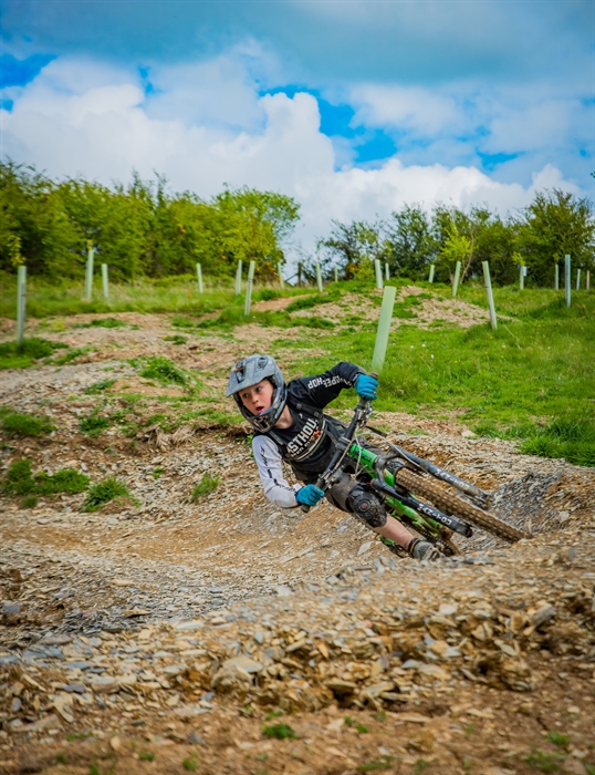 Action shot of a young male rider leant over riding a banked corner