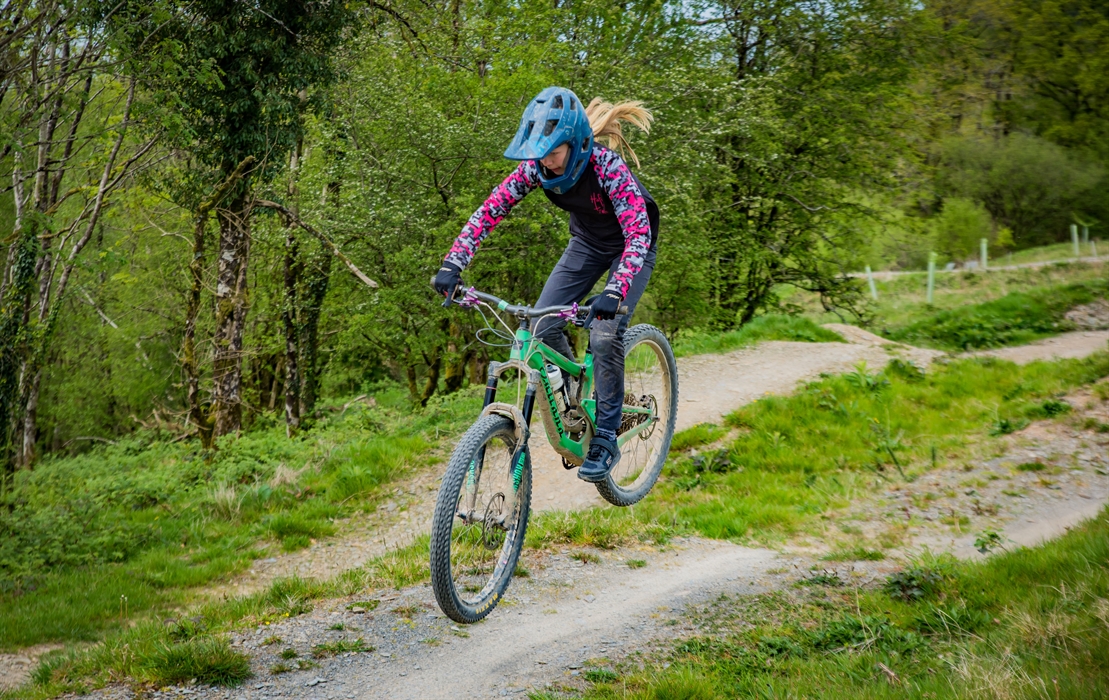 Action shot of a young female rider jumping a table top jump
