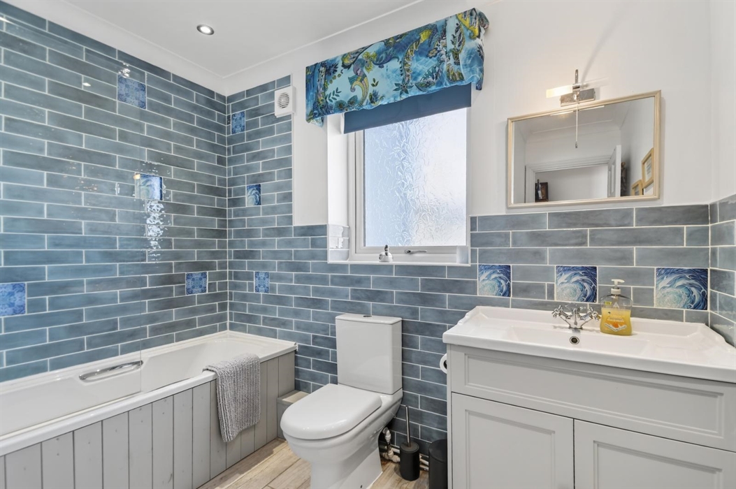 Refurbished master bathroom with an electric shower and also shower taps for washing kiddies hair, and a lovely vanity unit with a shaver point inside
