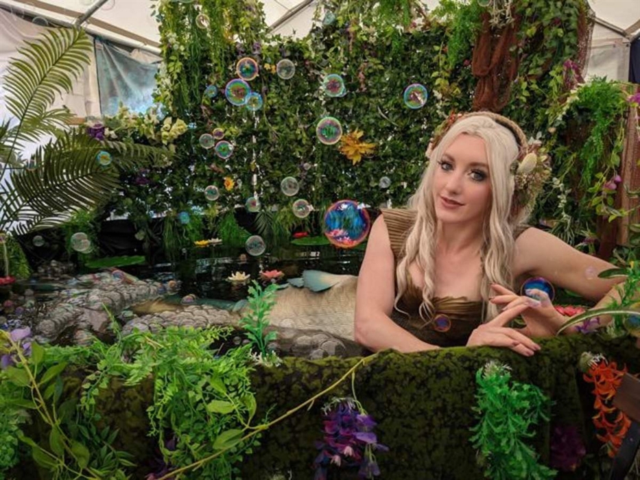 Mermaid Lagoon - a female in mermaid costume sat in a lagoon