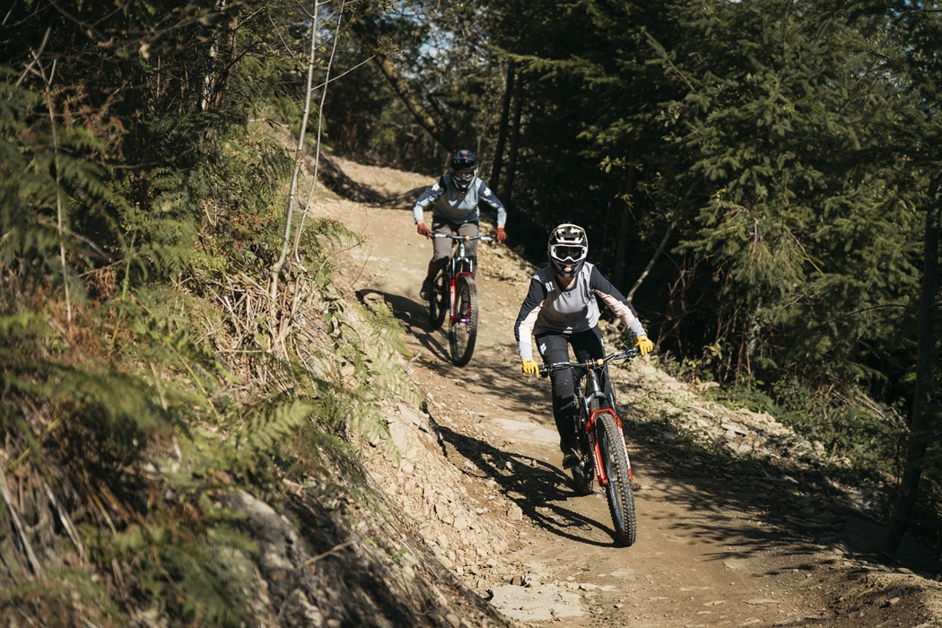 Two women riding down a trail