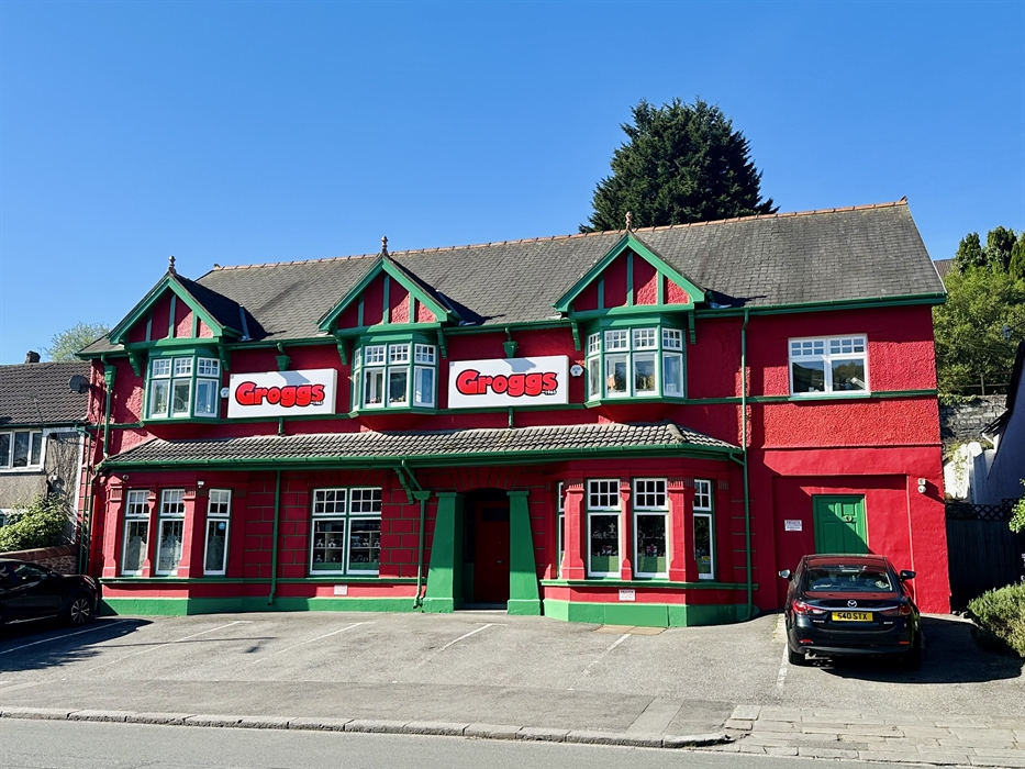 Photo shows a front view of the red and green building that has been The Groggshop since 1971.