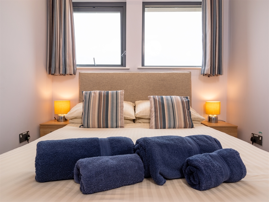 Cosy double room with bar table and chairs, television, and two windows with views directly onto the beach and water.