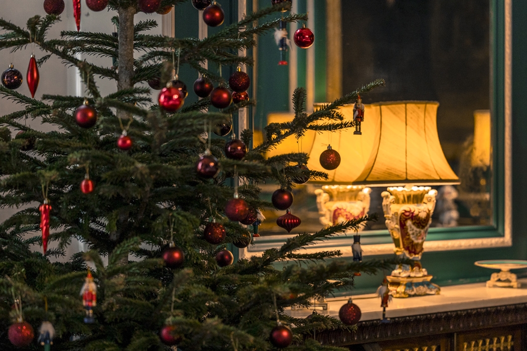A traditional Christmas tree with red festive decorations.