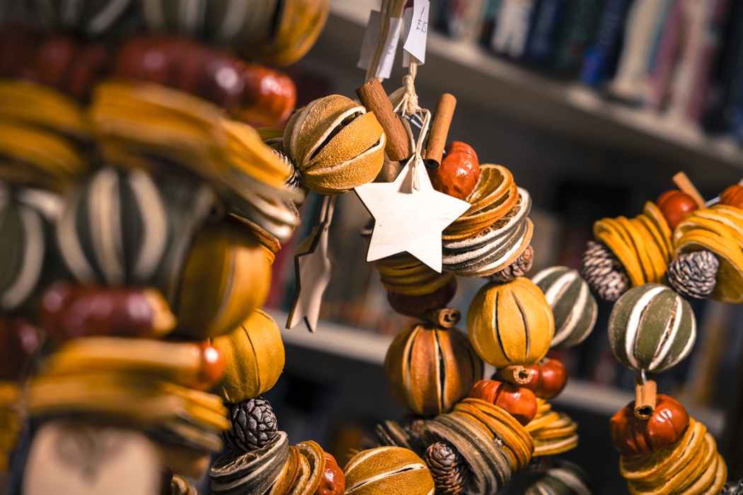 Close up of rustic Christmas wreaths made of dried oranges, pinecones and cinnamon.