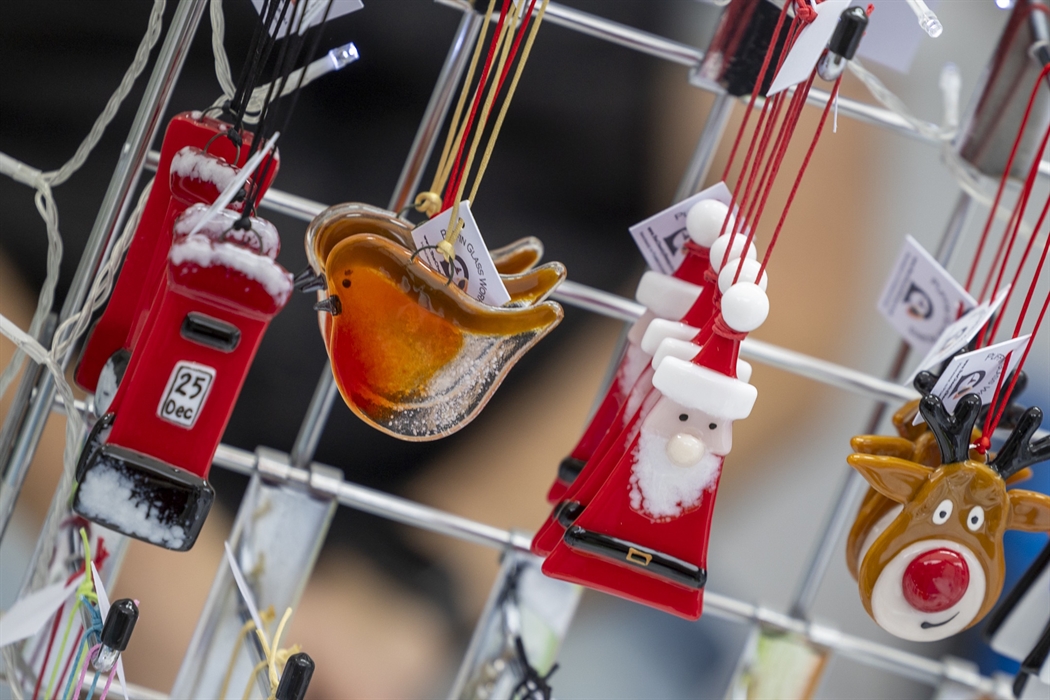 Close up of handmade Christmas decorations hanging on a stall display.