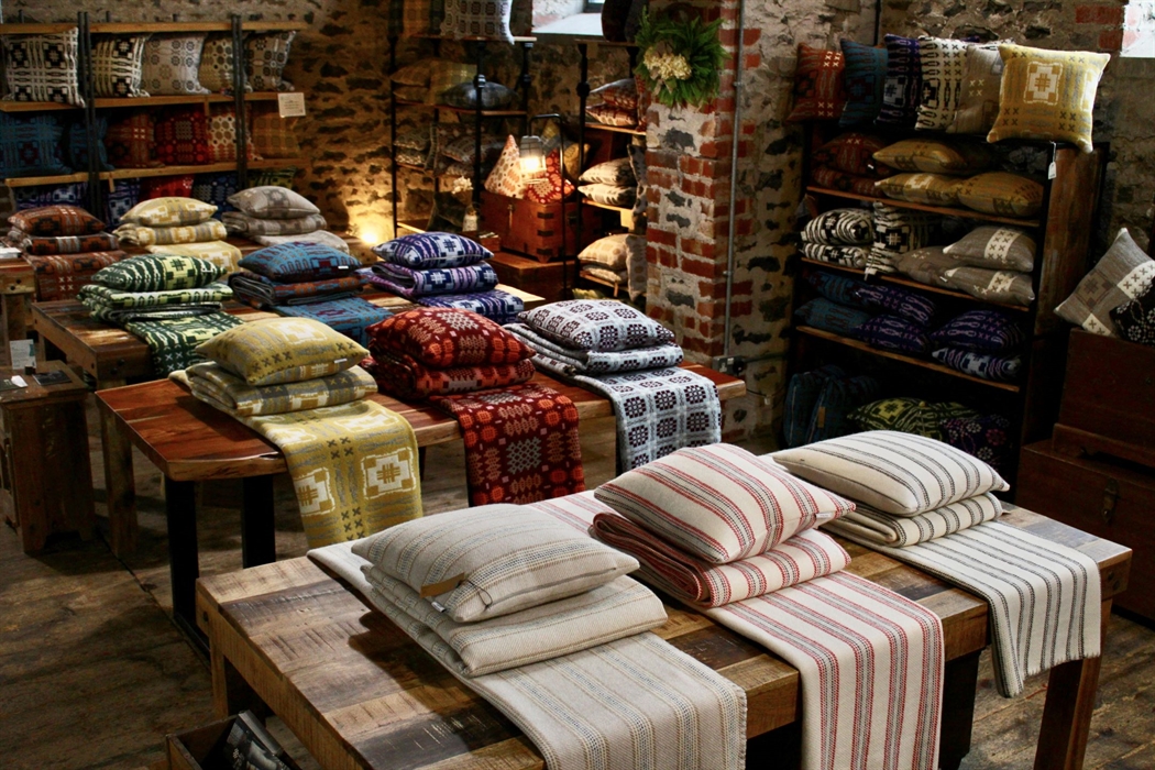 Blankets and cushions on tables in a shop