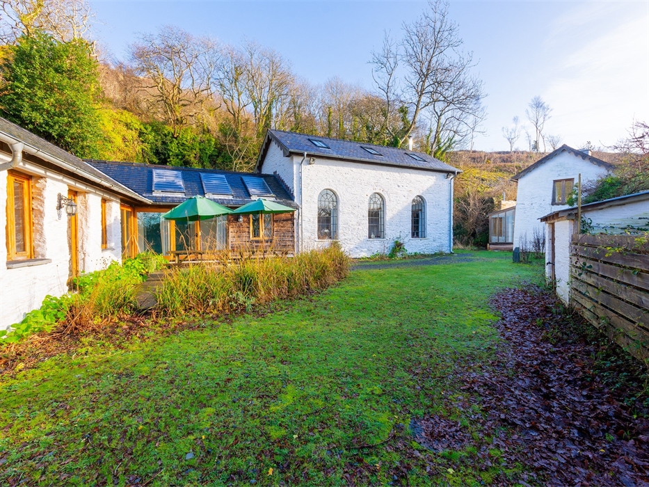 Outside area showing both cottages and grass, with trees behind