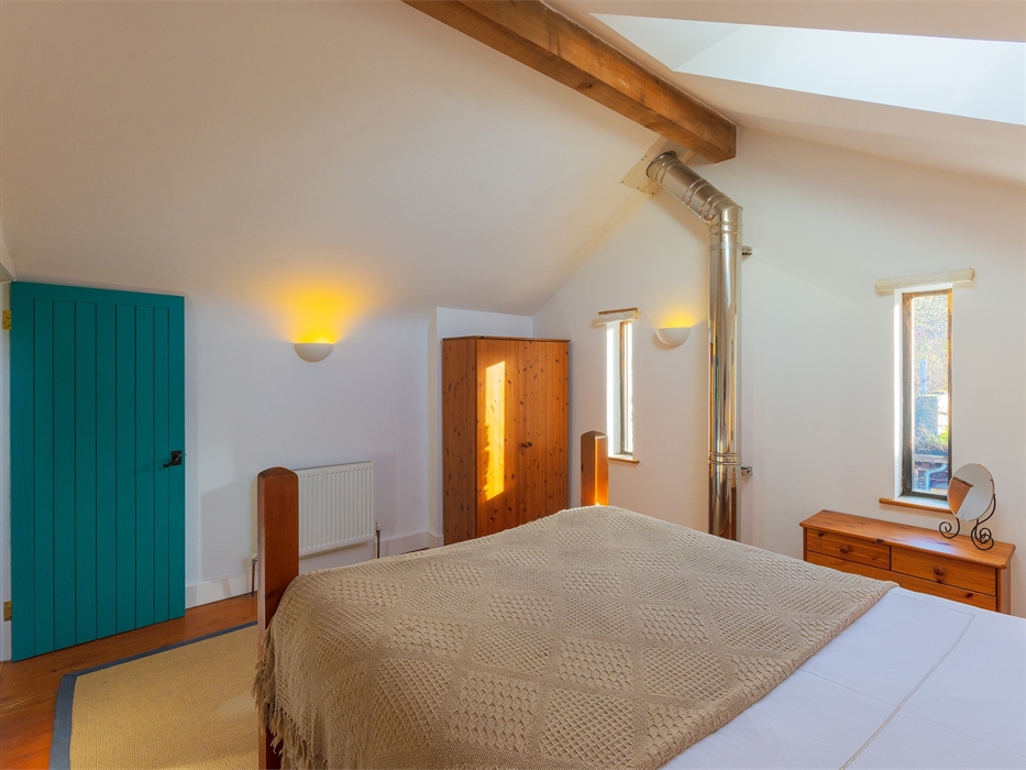 double bed with two windows and wardrobe