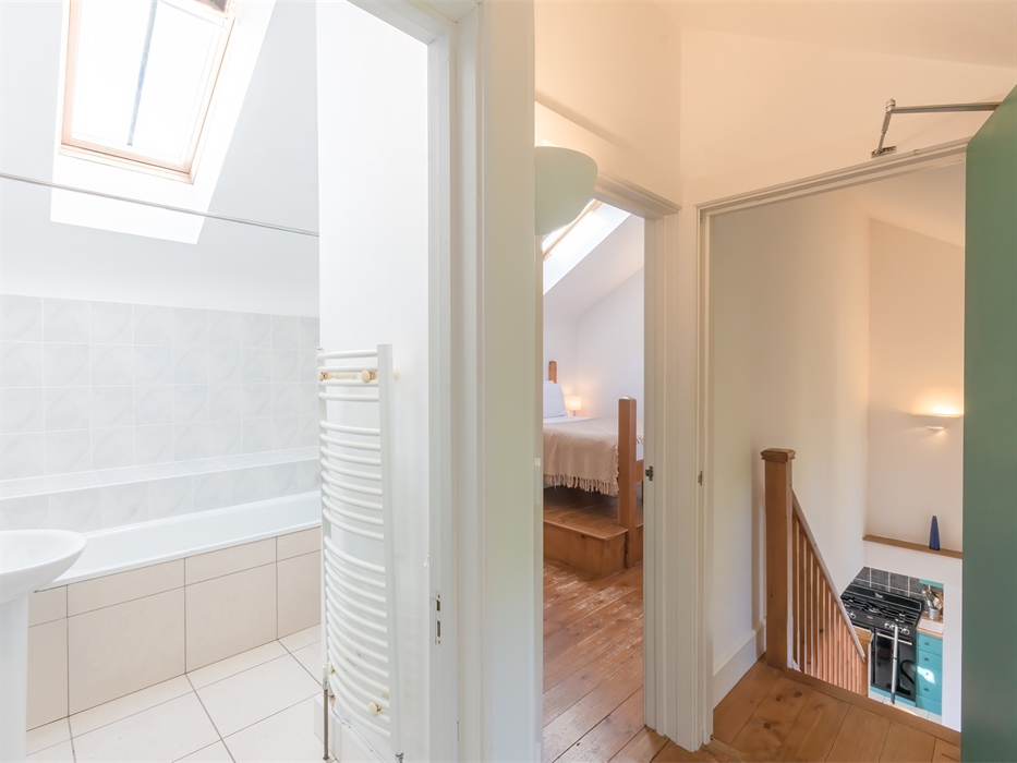 view of upstairs landing, showing bathroom and bedroom through doors