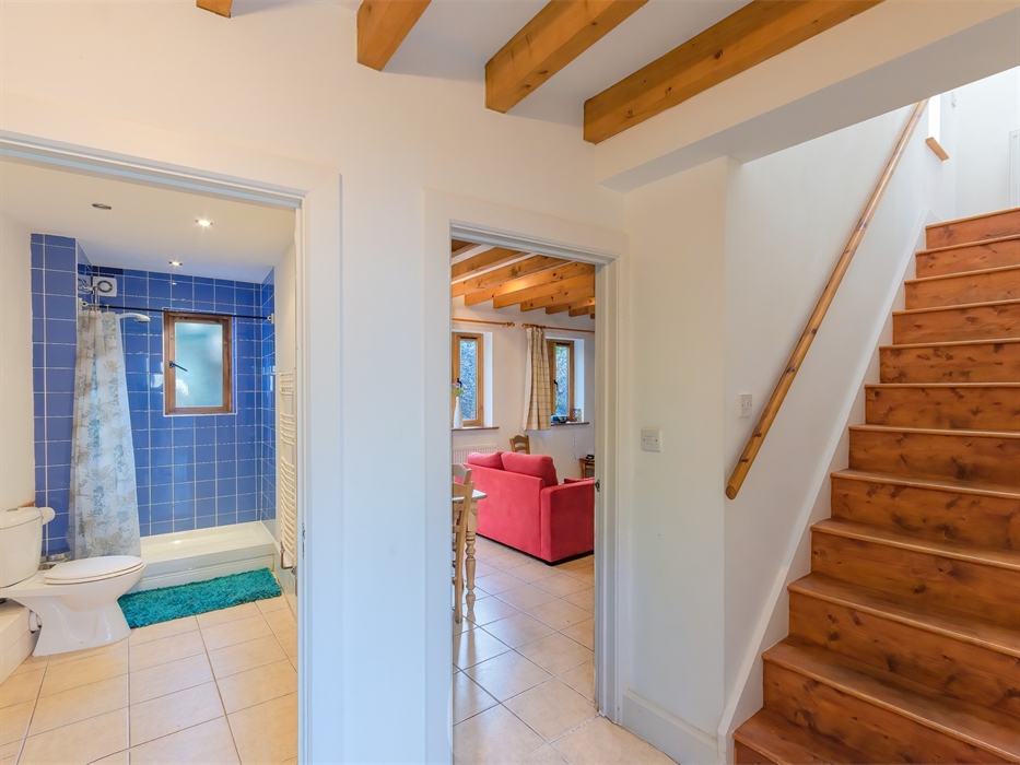 Quarry cottage, view from hallway into ground floor bathroom and living room and stairs going up to 1st floor