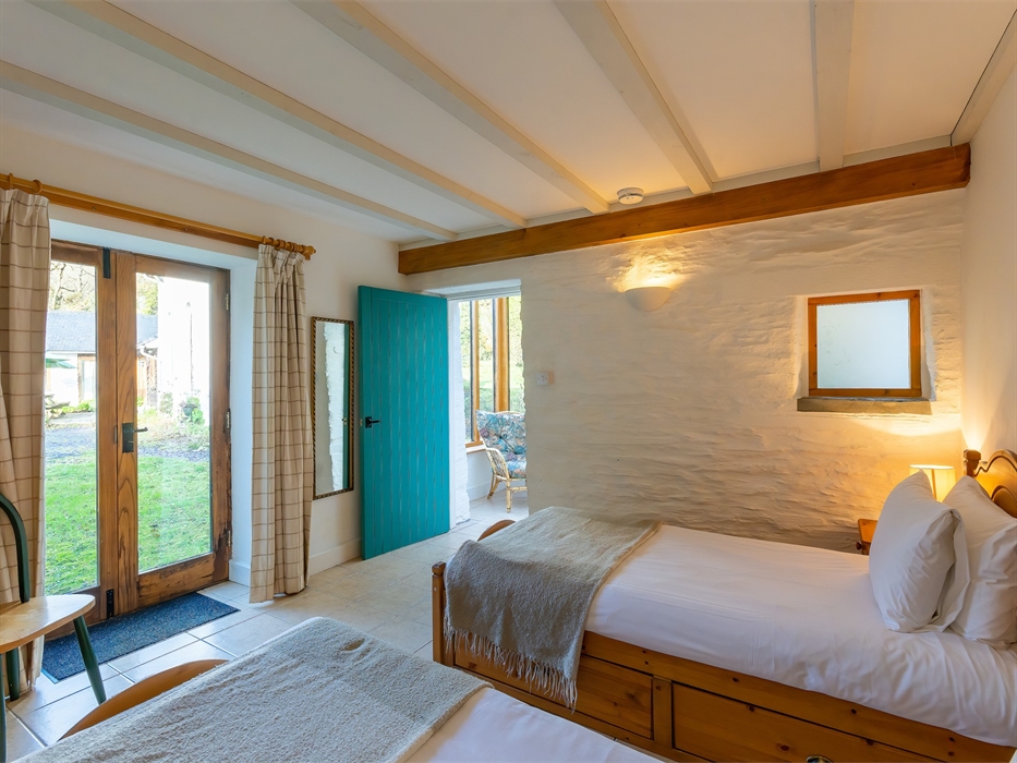 Twin beds with view to outside area through glass doors