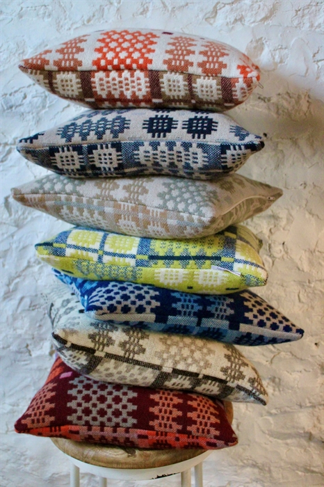 Colourful woven patterned cushions on a stool