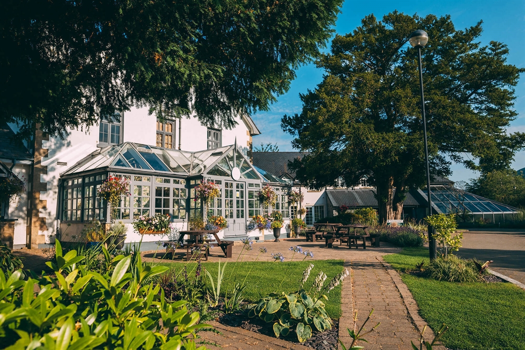Exterior of Wild Pheasant Hotel & Spa with a landscaped garden in the foreground and the hotel building in the background, showcasing the peaceful cou