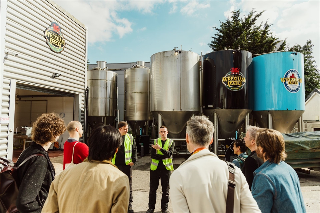 A group of people on a tour at a lager making attraction.