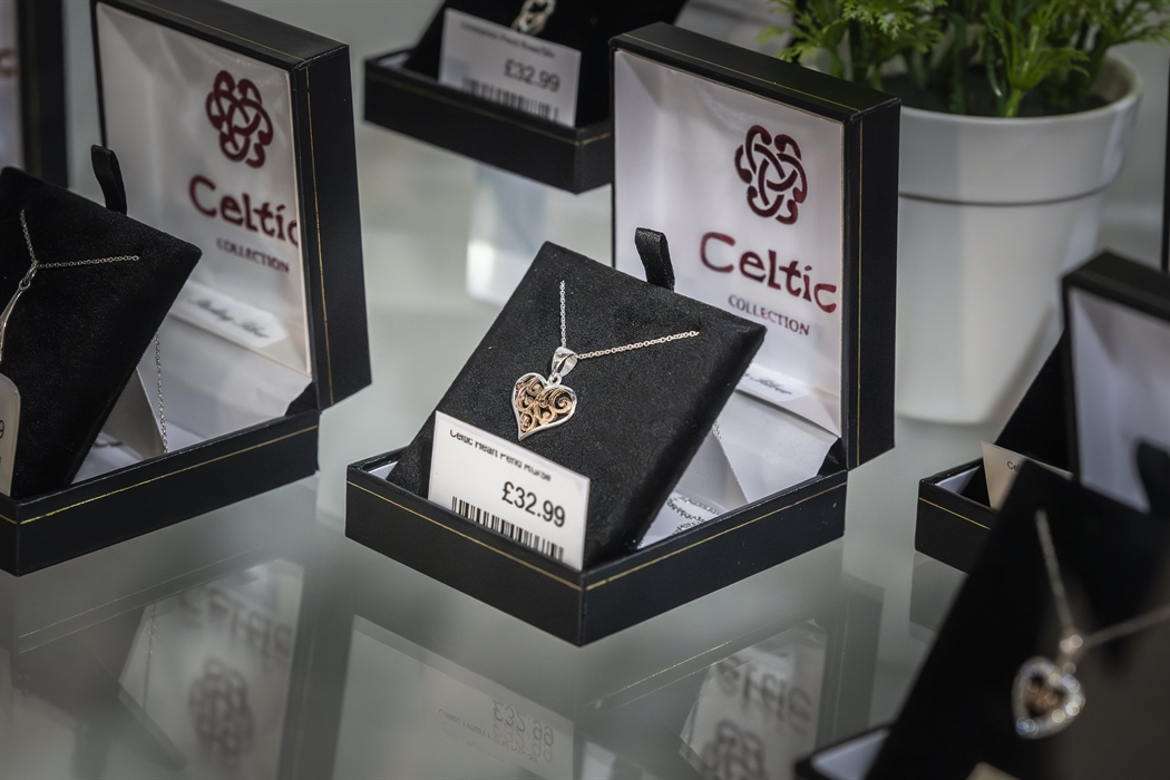 Celtic Collection jewellery display featuring silver heart necklaces and Welsh-inspired gifts in a glass cabinet.