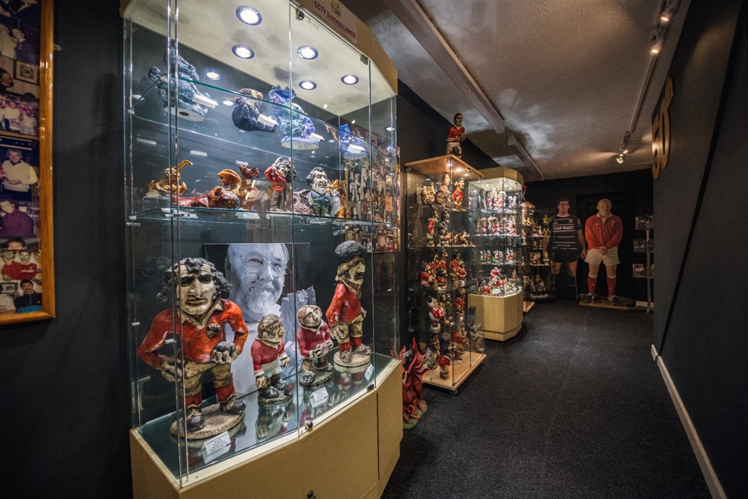 The picture shows a dark room with cabinets showcasing early Groggs.