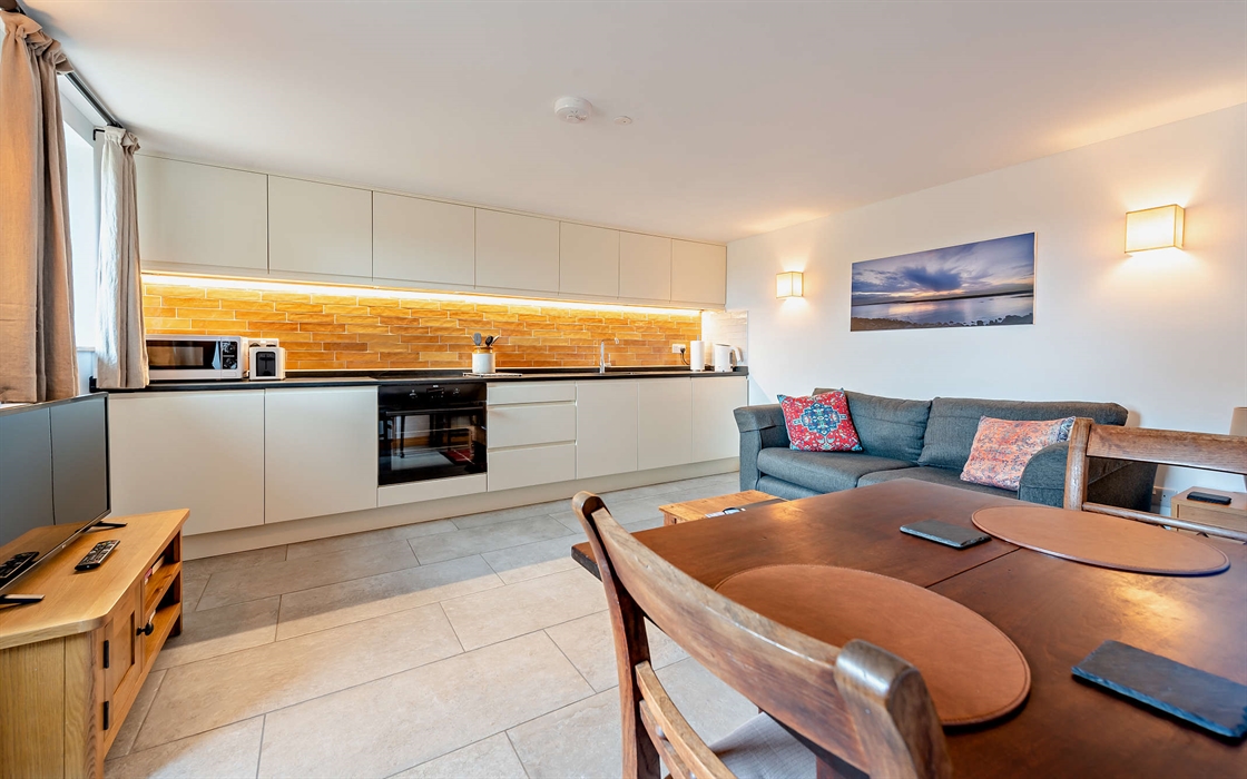 The open plan kitchen-lounge-dining space in the sustainable eco friendly apartment in Camarthenshire, is equipped with everything you will need.