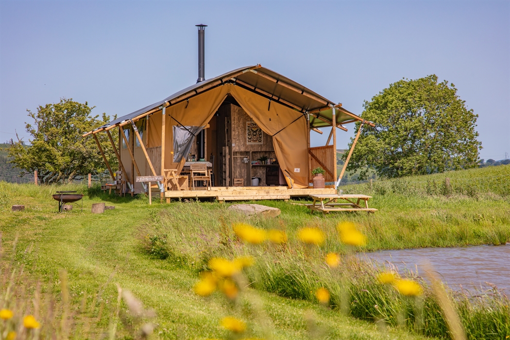 safari tent by a pond