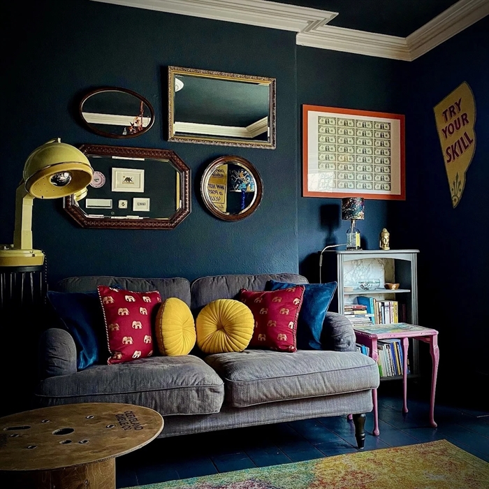 A lounge with black walls and mirrors on the wall