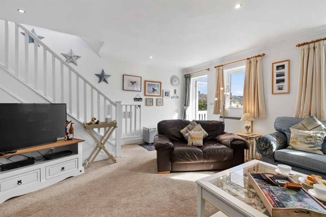 The lounge has access to the lower deck and garden and stairs for the bedroom access.